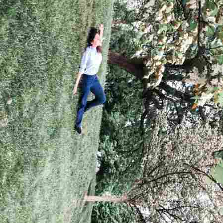 Aishah Hasnie lying down on the grass, experiencing the joy of nature