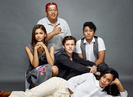Laura Harrier (white dress) pictured with the Spider-Man: Homecoming cast members Zendaya (left), Tom Holland (middle), Jacob Batalon, and Tony Revolori (right).