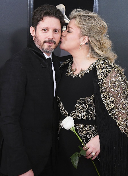 Kelly Clarkson kissing her partner Brandon Blackstock at a 60th Annual GRAMMY Awards on January 28, 2018