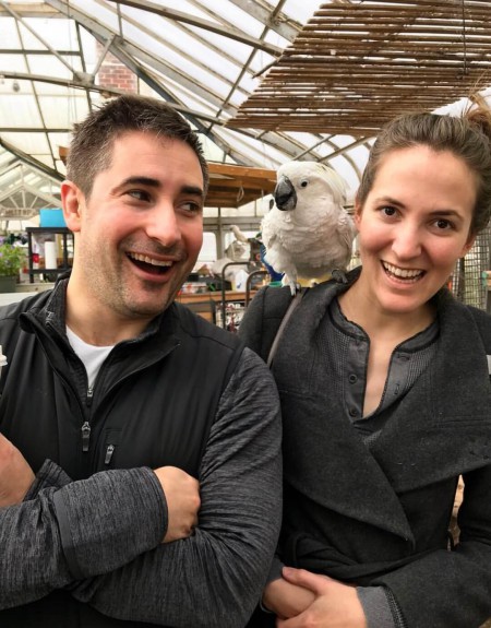 Jonathan Swan and Betsy Woodruff at a pet shop where a Parrot is sitting on her shoulder