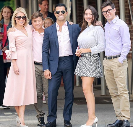Joaquin Antonio Consuelos with his parents and two siblings posing for a picture outdoor.