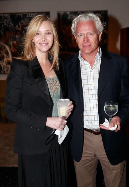Lisa Kudrow and Michel Stern attending an event where they are holding a drink