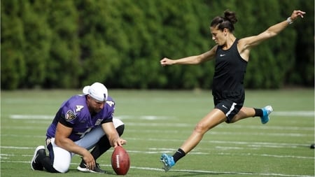 Carli Lloyd kicking a field goal with a pro NFL player