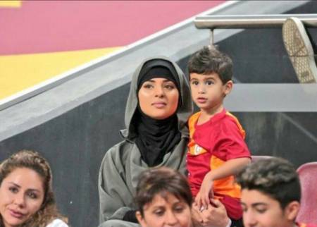 Amal Belhanda carrying her son, Muhammad Belhanda during the football match between Galatasaray vs. Genclerbirligi