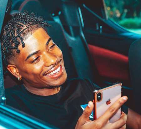 Tray posing with his gadget. Know more about Tray's age, youtube, songs, height, net worth as of 2019 and many more