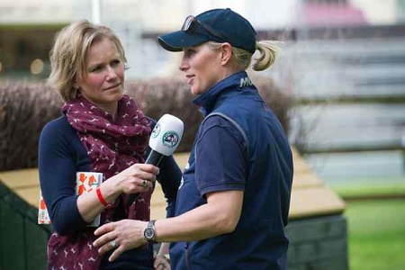 Lizzie Greenwood-Hughes taking interview at Badminton Horse Trials. Know more about Lizzie net worth, salary, remuneration, wages, insurance, bonds, shares, and other sources of income.