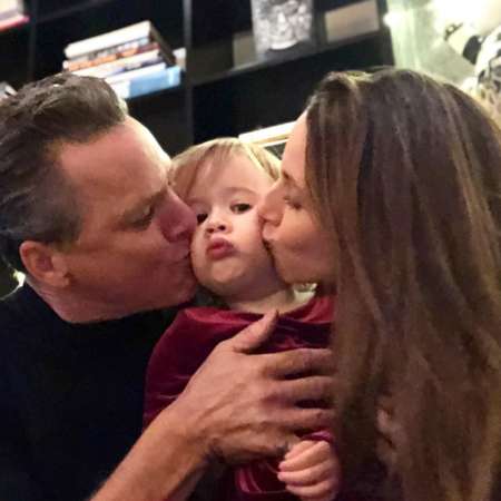 Alona Tal and Marcos Ferraez kissing on the cheeks of her daughter, Charlie Ferraez