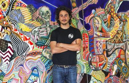 Zio Ziegler posing in front of his mural.