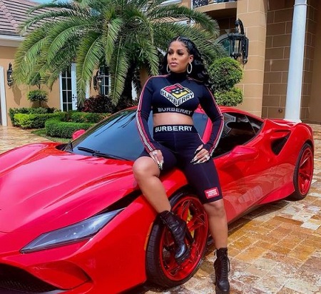 The Jamaican/American model, entrepreneur, Keyshia Ka'Oir poses on a red Ferrari.