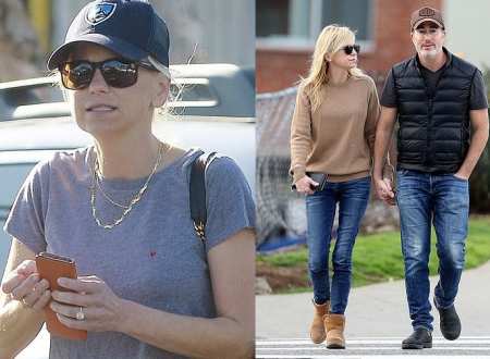 Anna Faris showing her engagement ring on the left side and walking with her fiance, Michael Barrett on the right side of photo