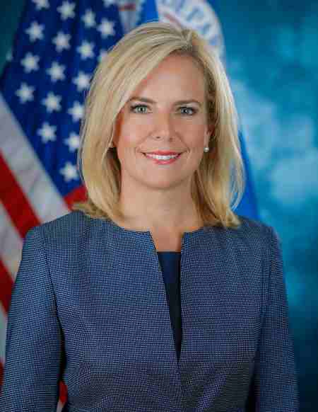 Kirstjen Nielsen is standing in front of the national flag of the United States. Is Nielsen married in 2020? Who is her husband?