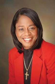 Photo of Venisha Brown wearing a red coat and cross locket in neck.