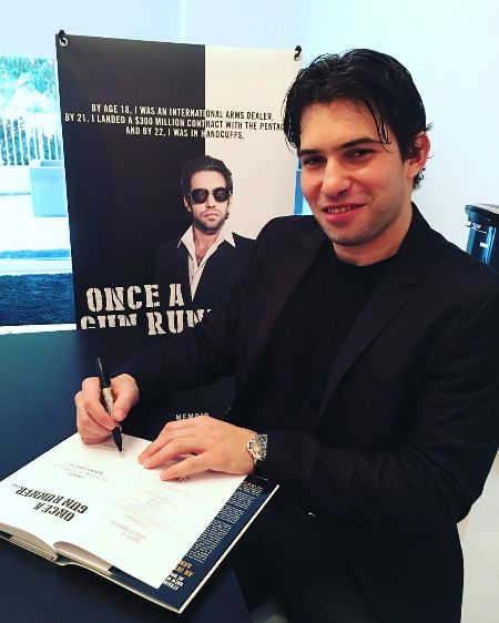 Dilveroli noting down autographs on his book "Once a Gun Runner" at the Miami Dade book fair. 