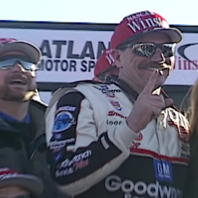 Dale Earnhardt can be seen smiling as his team is around him.