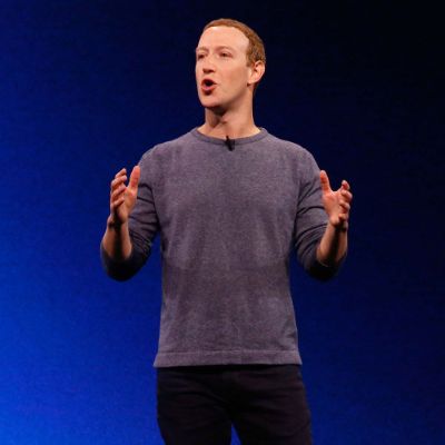 Mark Zuckerberg is wearing his signature grey shirt and a black pant.