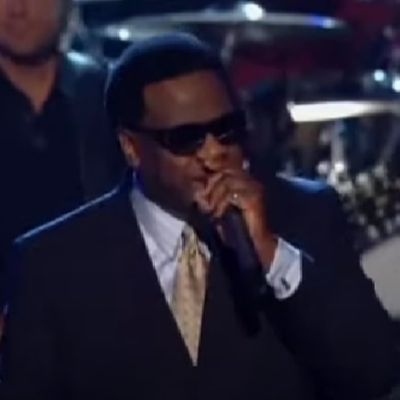 Shirley Kyles's husband, Al Green is on a suit and wearing a spec as he is performing.