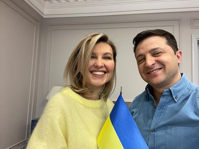 Olena Zelenska posing with her husband by wearing yellow sweater.