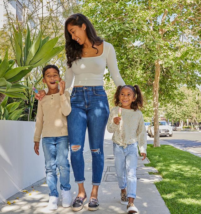 Apryl wearing blue jeans and white t-shirt, her children wearing blue jeans and cream color t-shirts.