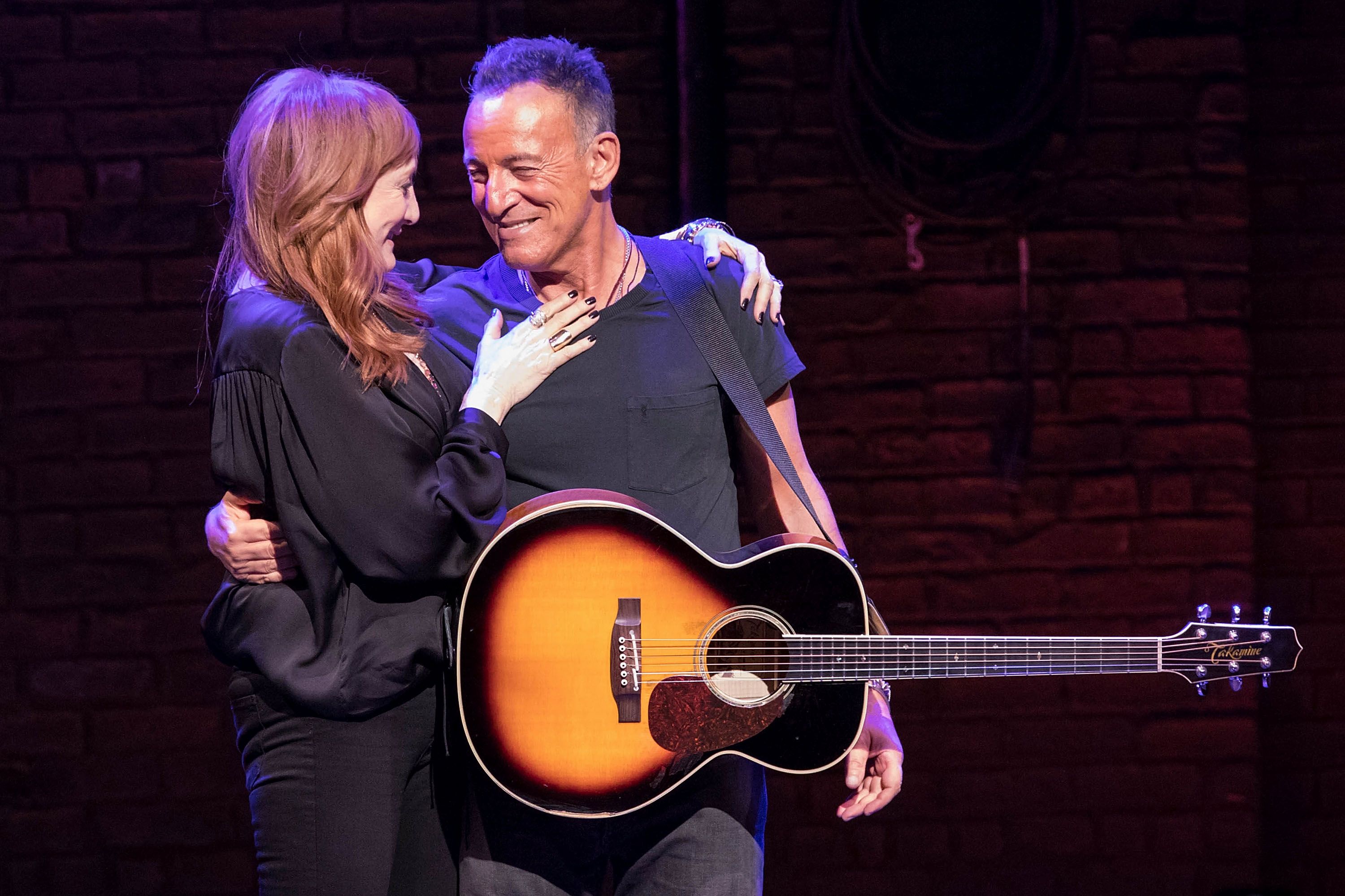 Patti Scialfa with her husband Bruce Springsteen posing with guitar