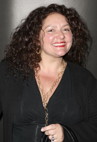 Aida Turturro wearing black dress and in a curly hair.