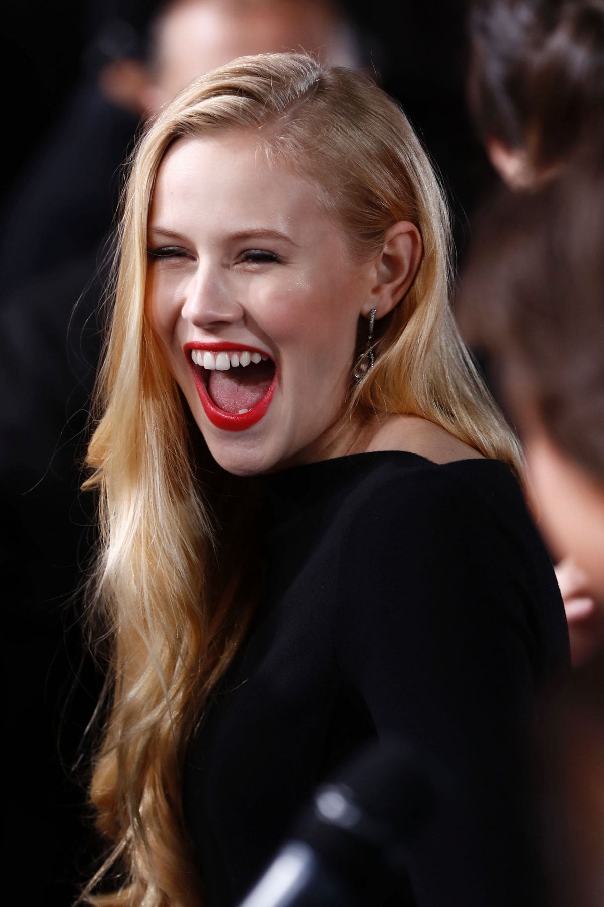 Danika Yarosh posing for the photo with a dark grey hair and a big laughter in her face.