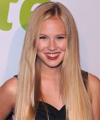 Danika Yarosh posing for the photo with a dark grey hair and a big smile in her face.