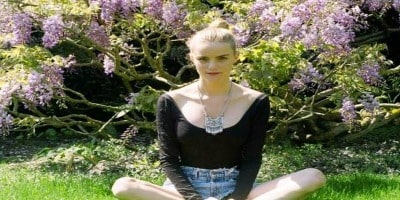 Picture of Solveig Karadottir wearing a black t-shirt and half jeans in a garden.