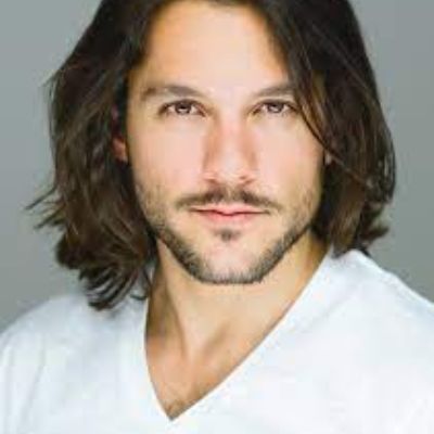 Picture of shahsr Issac with long hair and white shirt