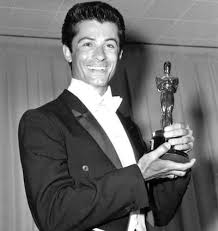 George Chakiris in his young age posing for the picture carrying award on his hand