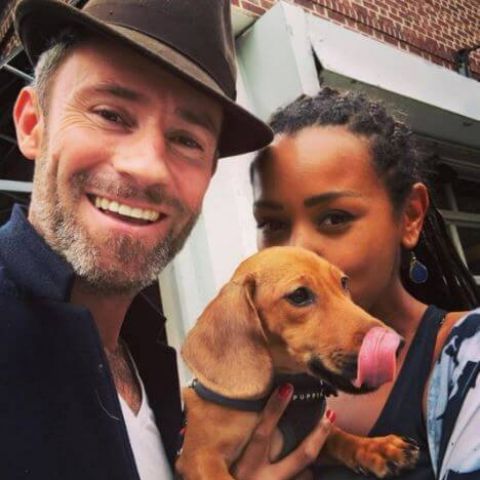 Picture of Melanie Liburd with her husband Benny Taylor and her pet wearing black and white color dress