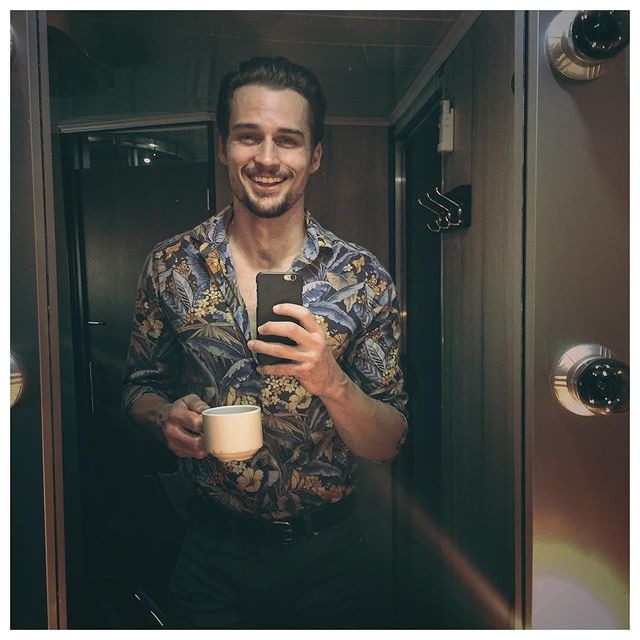 Picture of  Jon-Michael Ecker posing for a photoshoot wearing shirt and holding phone