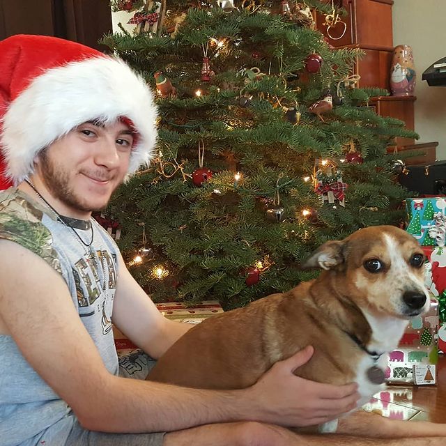 Picture of Atticus Shaffer wearing Christmas hat and his pet