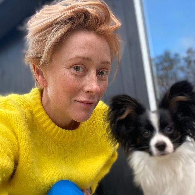 Picture of Maria Erwolter with her pet posing for a photoshoot wearing yellow color sweater