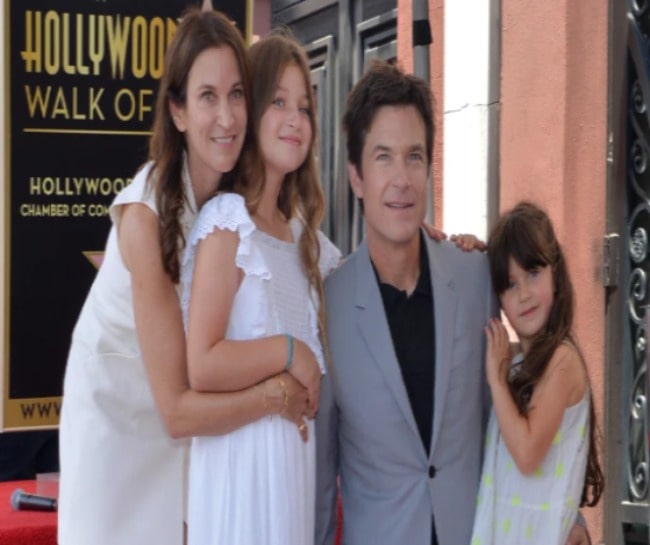 Picture of Maple Sylvie Bateman with her with her parents and sister wearing white color dress