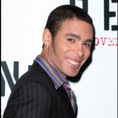 Wilson Jermaine Heredia was posing for a photo shoot by wearing a black suit.