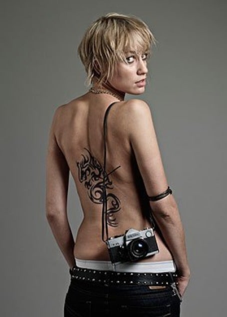 Luke Treadaway showing her dragon pattern tattoo.