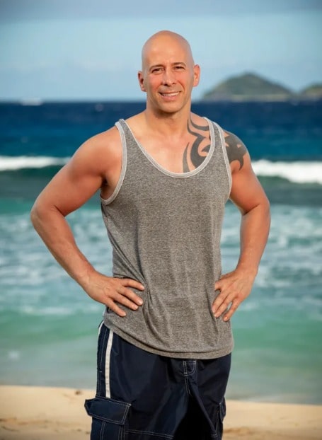 Tony Vlachos posing for a photo shoot in front of the beach