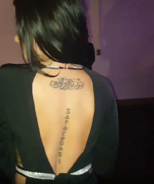 Golnesa Gharachedaghi showing her tattoo on the back while dancing in a party