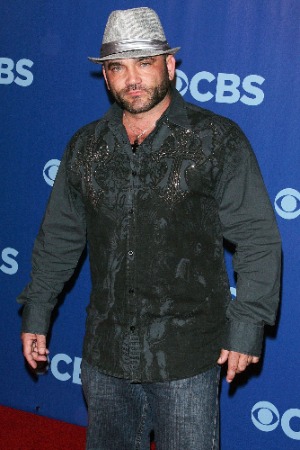 Russell Hantz wearing glittering black shirt and jeans on CBS presentation set 