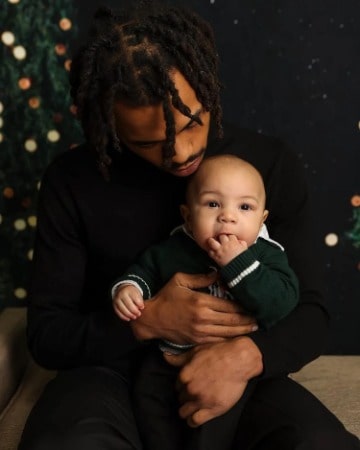 Joshua Omaru Marley with his baby son Caleb Messiah Marley in a formal black attire