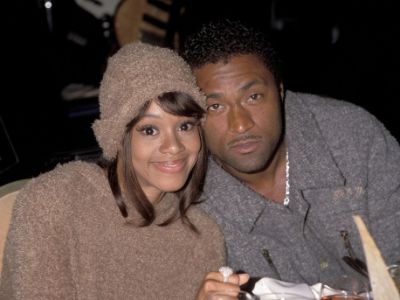 Lisa Lopes and Andre Rison are leaning their heads towards each other for the picture.