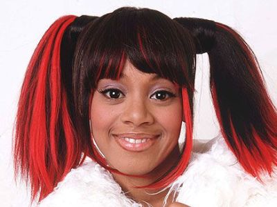 Lisa Lopes is wearing a white dress and has red and black hair.